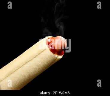 Französisch Hot Dog, in dem Wurst, Senf, Ketchup mit Dampf Rauch auf schwarzem Hintergrund. Fast Food Stockfoto