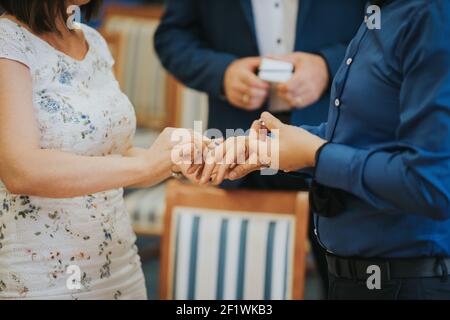 Ein flacher Fokus der Braut, die einen Ring aufsetzt Der Bräutigam während einer Hochzeitszeremonie Stockfoto