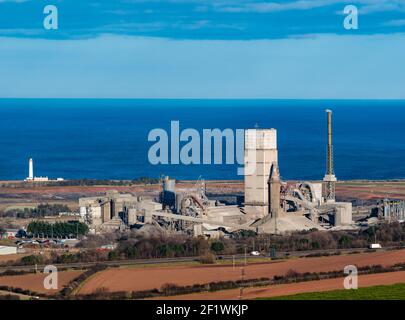 Industrietürme von Dunbar Zementwerk und Barns Ness Leuchtturm an der Küste, East Lothian, Schottland, Großbritannien Stockfoto