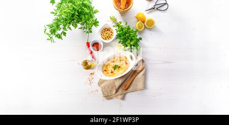 Hummuspaste mit Zitrone und Chili auf weißem Hintergrund Stockfoto