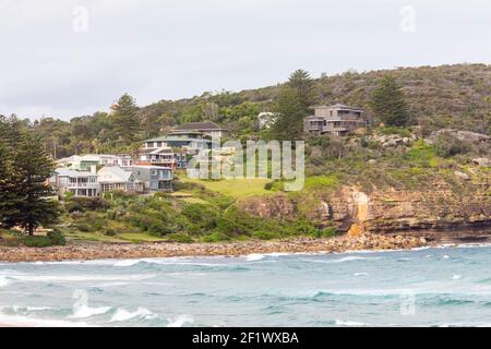 Sydney Häuser am Wasser auf einer Landzunge am Avalon Beach mit Küstenerosion als große Sandsteinfelsen haben sich von der rutschte Felswand, Sydney Nordstrand Stockfoto