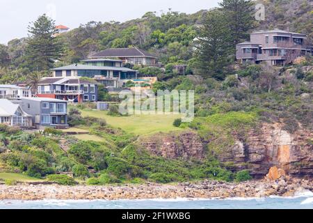 Sydney Häuser am Wasser auf einer Landzunge am Avalon Beach mit Küstenerosion als große Sandsteinfelsen haben sich von der rutschte Felswand, Sydney Nordstrand Stockfoto