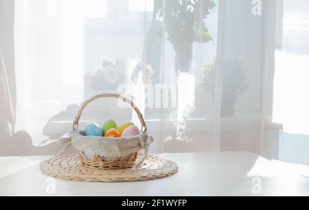 Ostern bunte Eier in busket auf weißem Holztisch. Frohe Ostern Hintergrund mit Copyspace. Stockfoto