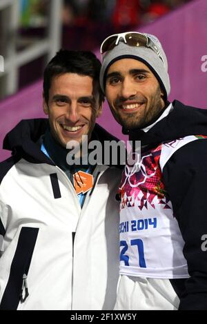 Martin Fourcade aus Frankreich holt die Goldmedaille während des Biathlon Männer Einzel 20km der XXII Olympischen Winterspiele Sotchi 2014, bei der komplexen Langlauf und Biathlon Laura, am 13. Februar 2014 in Sotschi, Russland. Foto Pool KMSP / DPPIHier wird er vom französischen olympiasieger im Kanu-Kajak Tony Estanguet gratuliert Stockfoto