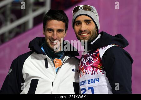 Martin Fourcade aus Frankreich holt die Goldmedaille während des Biathlon Männer Einzel 20km der XXII Olympischen Winterspiele Sotchi 2014, bei der komplexen Langlauf und Biathlon Laura, am 13. Februar 2014 in Sotschi, Russland. Foto Pool KMSP / DPPIHier wird er vom französischen olympiasieger im Kanu-Kajak Tony Estanguet gratuliert Stockfoto