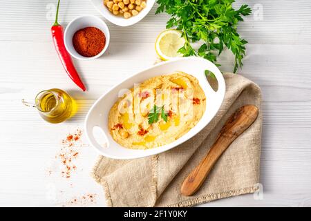 Hummuspaste mit Zitrone und Chili auf weißem Hintergrund Stockfoto