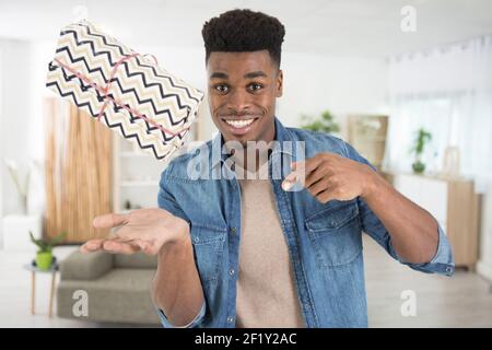 Porträt eines aufgeregten jungen Mannes, der ein Geschenk trägt Stockfoto