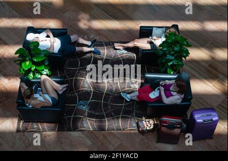 04,04.2018, Singapur, Republik Singapur, Asien - Menschen entspannen in Sesseln im Einkaufszentrum Shoppes in Marina Bay Sands. Stockfoto