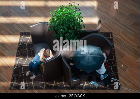 04,04.2018, Singapur, Republik Singapur, Asien - Menschen entspannen sich auf Sofas im Einkaufszentrum Shoppes in Marina Bay Sands. Stockfoto