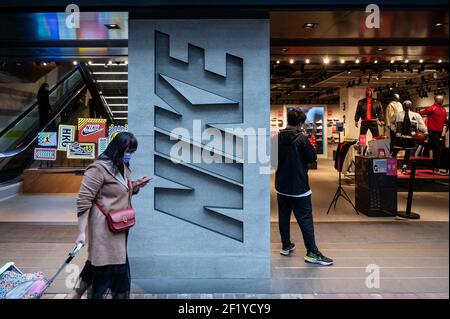 Hongkong, China. März 2021, 09th. Ein Fußgänger geht an der amerikanischen multinationalen Sportbekleidungsmarke, dem Nike Store und seinem Logo in Hongkong vorbei. Kredit: SOPA Images Limited/Alamy Live Nachrichten Stockfoto