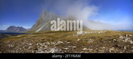 Berg Eystrahorn mit blauem Himmel und einer Nebelwolke, Wetterscheide, Ostisland, Island, Europa Stockfoto