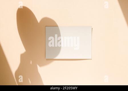 Leeres Papierblatt mit Hand- und Herzschatten-Overlay. Modernes und stilvolles Mock-up. Stockfoto