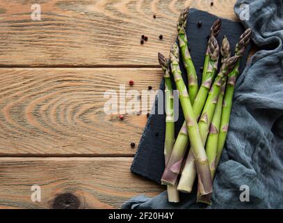 Frischer grüner Spargel auf altem Holztisch. Flach liegend Stockfoto