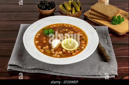 Der Teller mit der russischen oder osteuropäischen traditionellen Suppe soljanka oder soljanka vom Tisch. Hausgemachte Küche. Stockfoto