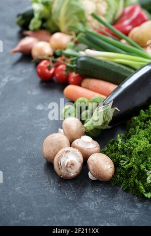 Viel frisches Gemüse verschiedener Sorten auf einer dunkelgrauen Schieferoberfläche, gesundes Lebensmittelkonzept für eine ausgewogene Ernährung, Kopierraum, ausgewählter Fokus, nar Stockfoto