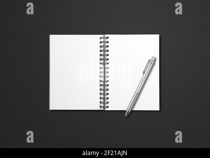 Blank offenes Spiral Notizbuch und Stift isoliert auf schwarz Stockfoto