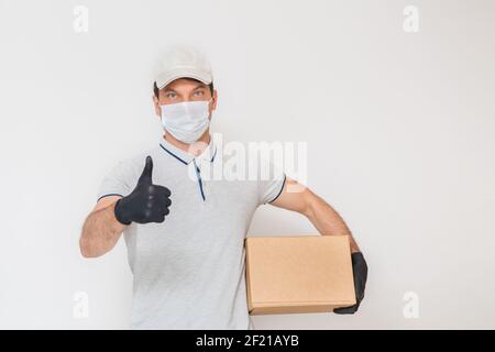 Kurier in medizinischen Gummihandschuhe und Schutzmaske hält Kartons. Türzustellung. Essen zum Mitnehmen. Lieferservice. Quarantäne. Coronavirus. Stockfoto