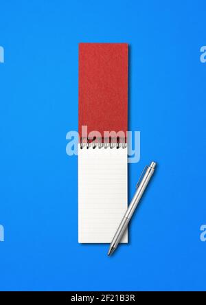 Blank offene Spirale Notizbuch und Stift isoliert auf blau Stockfoto