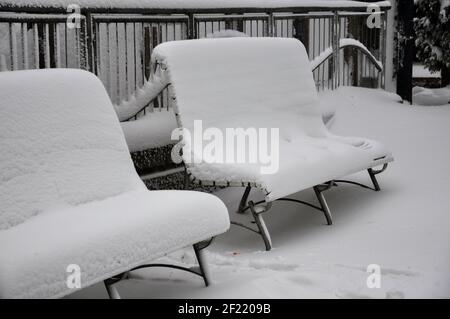 Zwei verschneite Bänke im Winter können Sie einige Schritte sehen Vor ihnen Stockfoto