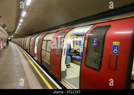 Passagiere und covid 19 Pandemie Gesicht Abdeckung und soziale Distanzierung Schilder auf die londoner U-Bahn-Züge 2021 Stockfoto