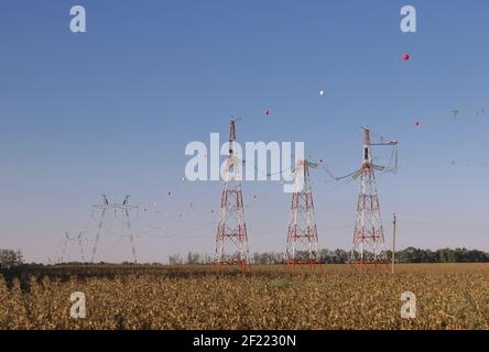 Farbige Kugel für den Flugverkehr hängt von einem Hochspannungskabel. Hochspannungs-Stromleitung Türme mit Kugeln hängen auf Stromleitung für Warnung Pilot, low flyi Stockfoto