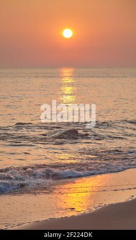 Goldener Sonnenuntergang über dem Meer, selektiver Fokus auf Felsen. Stockfoto