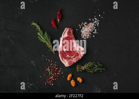 Blick von oben auf rohe Steaks im Dunkeln Hintergrund Stockfoto