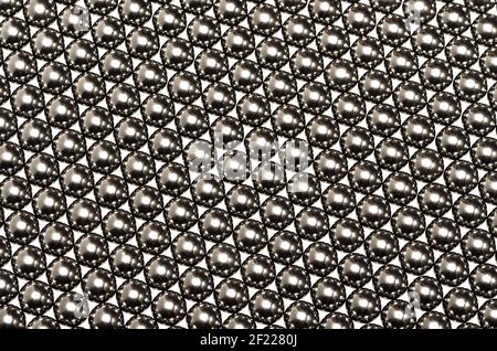 Große Anzahl von gleichmäßig verteilten Kugellagern. Reflexionen, die eine optische Illusion von Sechsecken geben Stockfoto