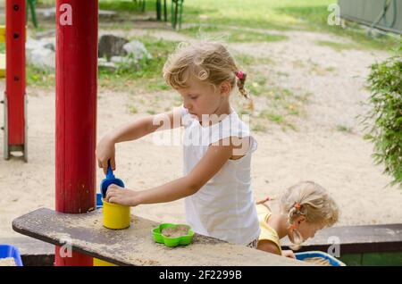 Schöne blonde Mädchen spielen auf dem Spielplatz Stockfoto