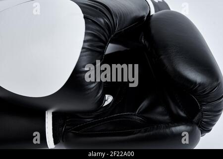 Paar schwarze Boxhandschuhe auf weißem Hintergrund, Nahaufnahme Stockfoto