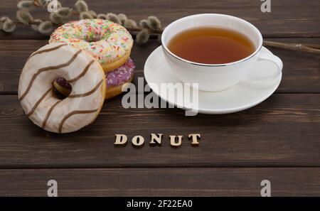 Köstliche Donuts und heißen Tee. Donut mit Puderzucker und einem hellen streuen gekrönt. Frühstück am Morgen Stockfoto