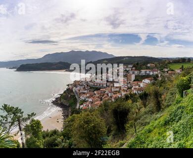 Ein schönes kleines Dorf an der Küste von Asturien eingebettet Auf einem Hügel Stockfoto