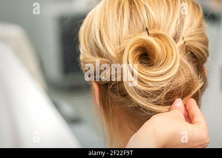 Nahaufnahme der weiblichen Friseur Styling blonde Haare von einem Junge Frau in einem Schönheitssalon Stockfoto