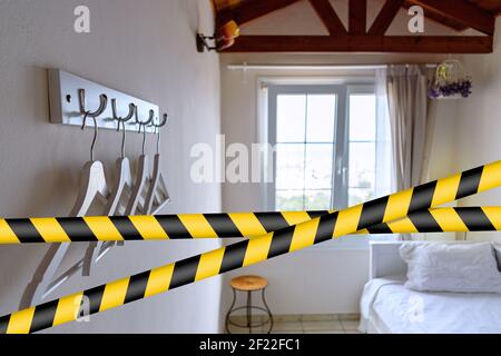 Vier Kleiderbügel, die an Haken an einer weißen Wand im Zimmer hängen. Stockfoto