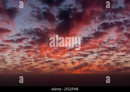 Fantastischer Anblick eines Abendhimmels in verschiedenen Schattierungen Rote und viele kleine Wolken Stockfoto