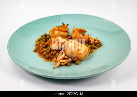 Zweiter Gang mit Tintenfisch und Tomatenerbsen auf einem weißen Hintergrund Stockfoto