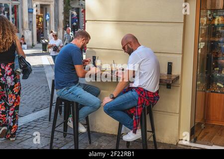 ATHEN, GRIECHENLAND - 30. Oktober 2019: Zwei männer schauen auf ihre Telefone in Café. Stockfoto