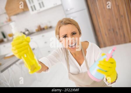 Hausfrau in Schürze und Handschuhe suchen aufgeregt Stockfoto