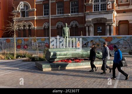 Die Bronzeskulptur eines Jungen ist Teil des Kunstwerks von Kenny Hunter am Walworth Square at Elephant and Castle am 9th. März 2021 in London, England. Die vollständige Inschrift lautet: „Gegen die Rüstung des Sturms halte ich meine menschliche Barriere fest“ – eine Zeile aus einem Gedicht aus dem Zweiten Weltkrieg von Hamish Henderson. Das eindrucksvolle Bronzekunstwerk wurde im Jahr des 100. Jahrestages des Waffenstillstands und des Endes des Ersten Weltkriegs installiert. Die Skulptur wurde beauftragt, an alle Leben zu erinnern, die von Krieg und Konflikten auf der ganzen Welt betroffen sind, einschließlich des Lebens von Mitgliedern des A Stockfoto