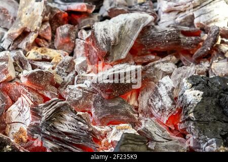 Hintergrund von brennenden heißen Kohlen im Grill. Stockfoto