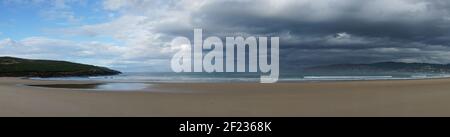 Panorama auf einen leeren und großen schönen goldenen Sandstrand Unter einem schlechten Wetterhimmel Stockfoto