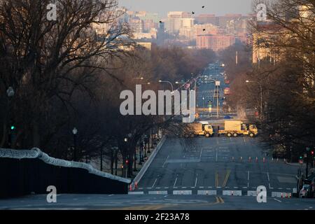 Washington, USA. März 2021, 10th. Fahrzeuge der Nationalgarde blockieren die Constitution Avenue im Sicherheitsbereich des US-Kapitols bei Sonnenaufgang in Washington, DC, am Mittwoch, den 10. März, 2021. Heute wird das Parlament eine Version von Präsident Bidens $1,9 Billionen COVID-Entlastungsgesetz verabschieden, das $1400 Stimulus-Checks für viele Amerikaner beinhaltet, da der Senat diese Woche mit mehreren Kabinett-Bestätigungen weitergeht. (Graeme Sloan/Sipa USA) Quelle: SIPA USA/Alamy Live News Stockfoto