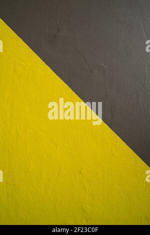 Gelb und grau bemalte Wand, Hintergrund. Stockfoto