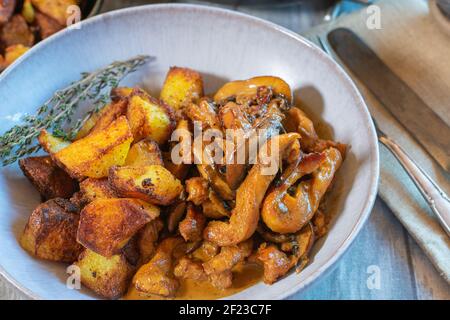 Fleisch mit Pilzsahnesauce und Bratkartoffeln anbraten Eine Platte Stockfoto
