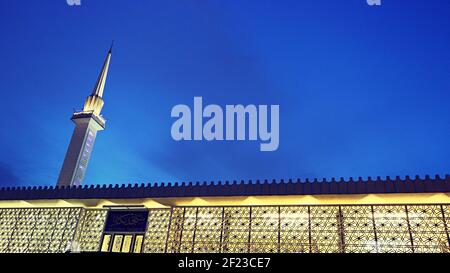 Nationale Moschee von Malaysia bei Nacht: Das beleuchtete Minarett und das Äußere des Masjid Negara in Kuala Lumpur Stockfoto