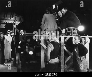 JOHN MacDowell GINGER ROGERS NORMAN FOSTER und Director MONTA BELL Am Drehort offen mit Film Crew in New York Während der Dreharbeiten des JUNGEN MANNES VON MANHATTAN 1930 Regisseur MONTA BELL Paramount Pictures Stockfoto