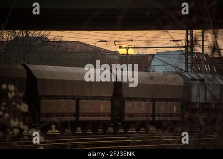 03. März 2021, Sachsen-Anhalt, Magdeburg: Die Sonne untergeht hinter Güterwagen, die in den Hauptbahnhof einziehen. Foto: Stephan Schulz/dpa-Zentralbild/ZB Stockfoto