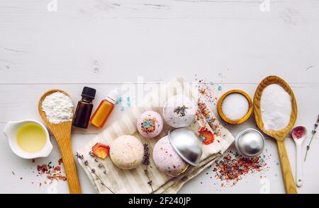 Machen Bad fizz Bomben zu Hause Konzept. Alle Zutaten auf dem Tisch auf Holzlöffeln: Maisstärke, ätherisches Öl, Farbstoff, Zitronensäure, Backpulver. Stockfoto