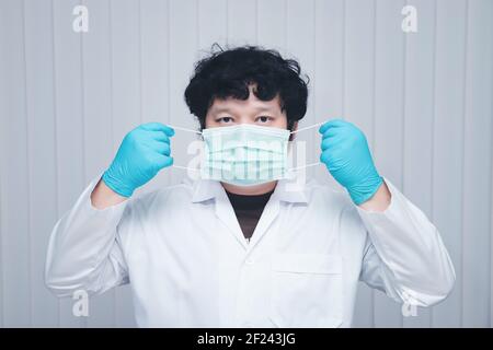 Arzt, der beim Ausbruch des Coronavirus, Covid-19, medizinische Maske und Handschuhe trägt. Stockfoto