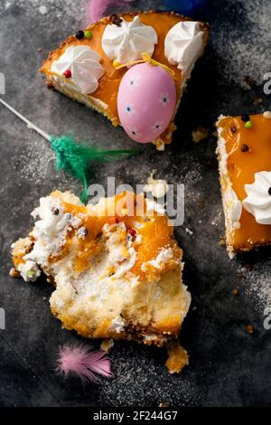 Blick in die Höhe von einigen Stücken einer spanischen mona de pascua, ein Kuchen gegessen am Ostermontag, mit einem verzierten Ei und Federn von verschiedenen geschmückt Stockfoto